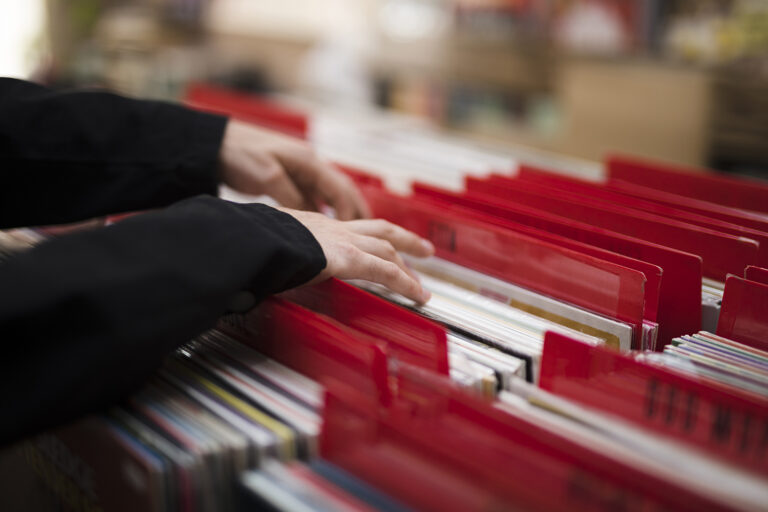 krupnym-planom-molodoi-celovek-iset-vinily-v-magazine